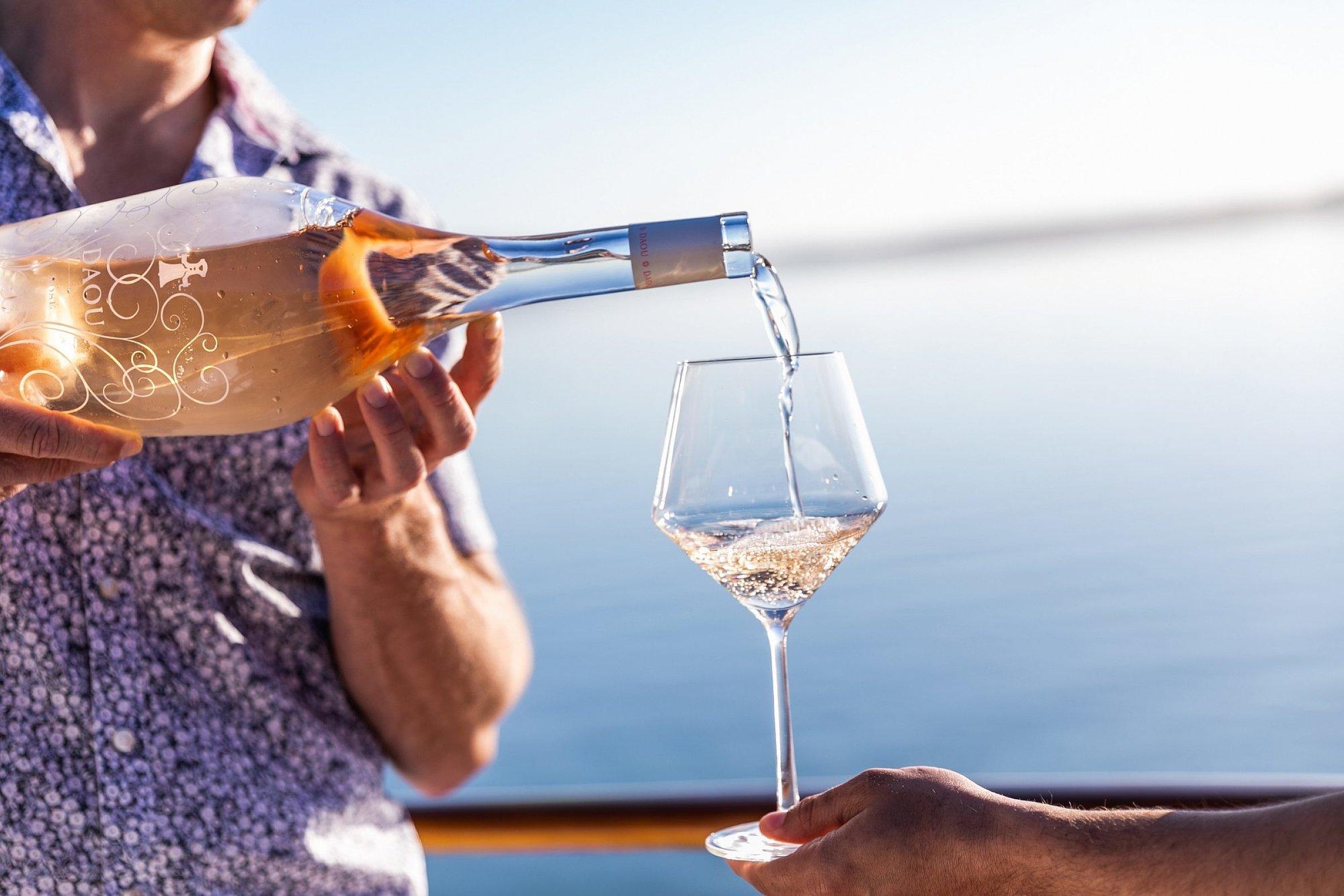 A person pours rosé into a glass